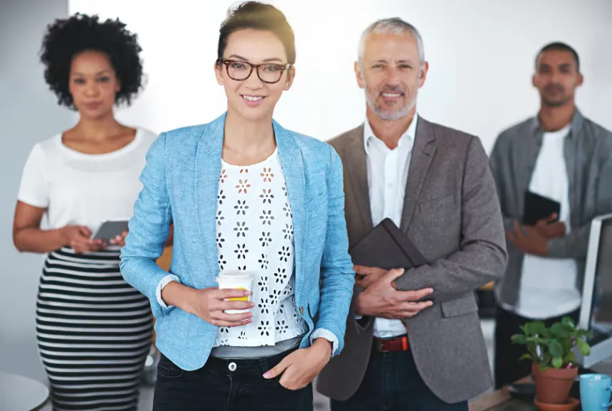 Group of professional businesspeople standing confidently in office as business directory lists your business
